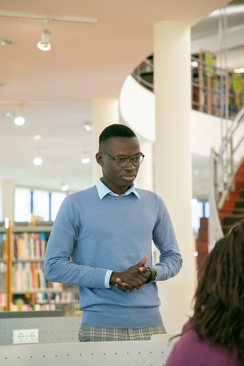 黑人学生站在图书馆的观众面前 · 免费素材图片