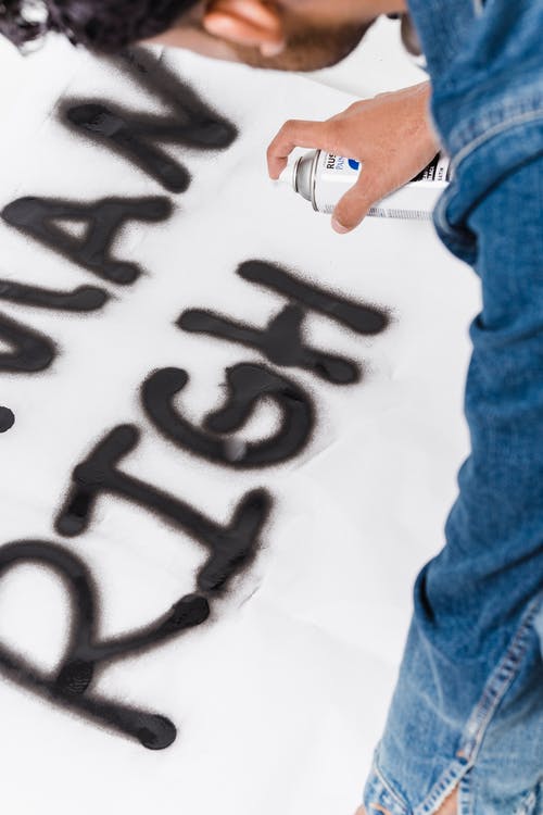 蓝色牛仔牛仔裤的人喷漆人权一词 · 免费素材图片