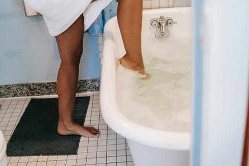 族裔女人把腿放在浴 · 免费素材图片