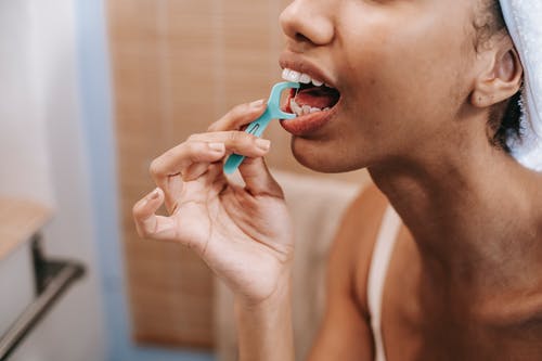 族裔女人用牙线清洁牙齿 · 免费素材图片