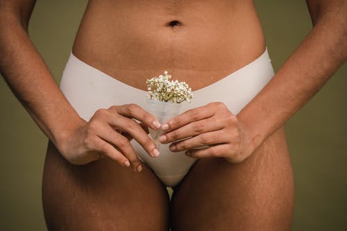 白色内裤的妇女与在她的膝部的白花 · 免费素材图片