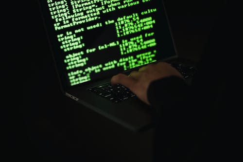在屏幕上显示信息的笔记本电脑上打字的作物黑客 · 免费素材图片