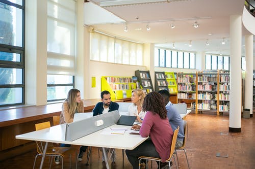 多民族学生在图书馆一起做研究 · 免费素材图片