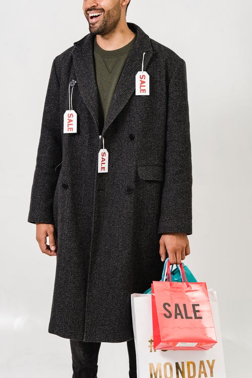 穿灰色大衣与销售标签的男人 · 免费素材图片