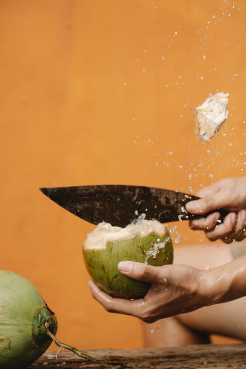 裁剪人用刀切椰子 · 免费素材图片