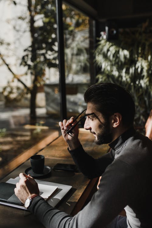 黑船员的脖子t恤，拿着智能手机的人 · 免费素材图片