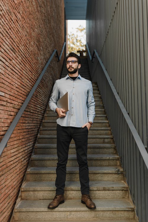 白色礼服衬衫和黑色的裤子，站在棕色木制楼梯上的男人 · 免费素材图片