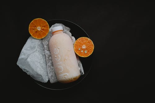 柑橘类水果汁在黑色背景上 · 免费素材图片
