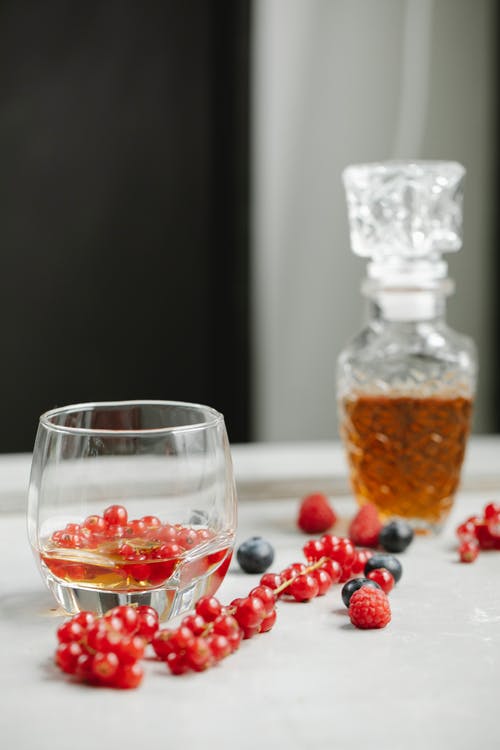 杯威士忌与浆果桌上 · 免费素材图片