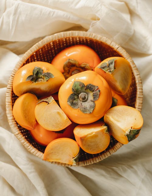布朗编织篮子上的橙色水果 · 免费素材图片