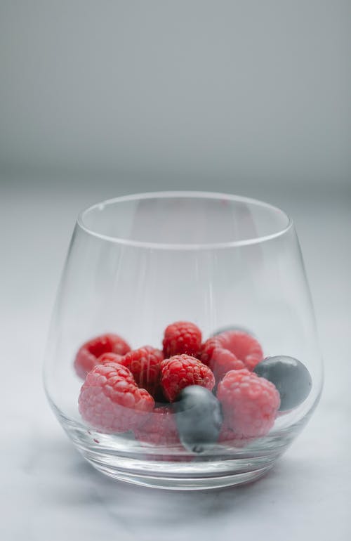 杯新鲜浆果在桌子上 · 免费素材图片