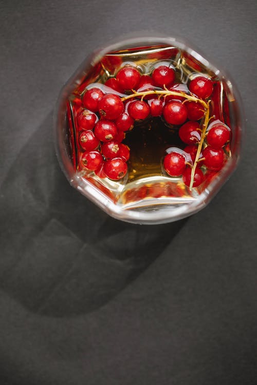 玻璃与桌上的红色浆果 · 免费素材图片