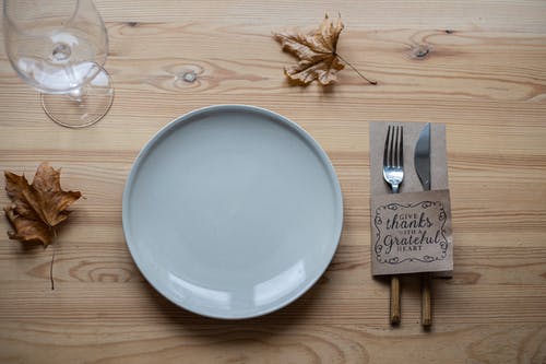 不锈钢叉和面包刀旁边的白色陶瓷板 · 免费素材图片