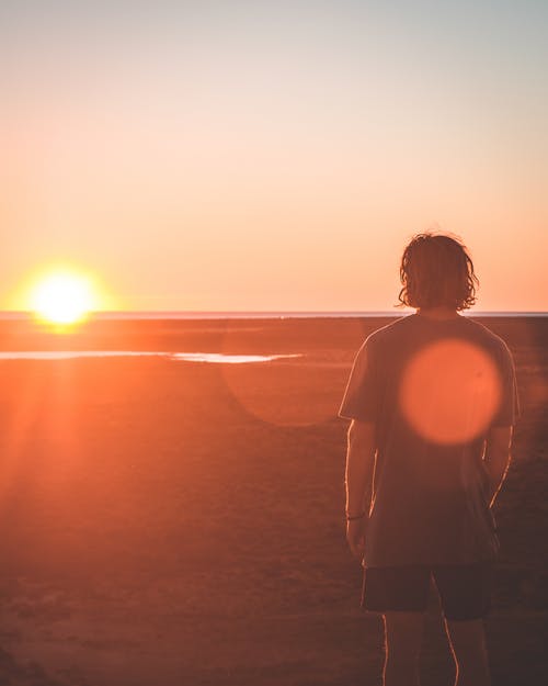 不可识别的人在海滩上享受日落 · 免费素材图片