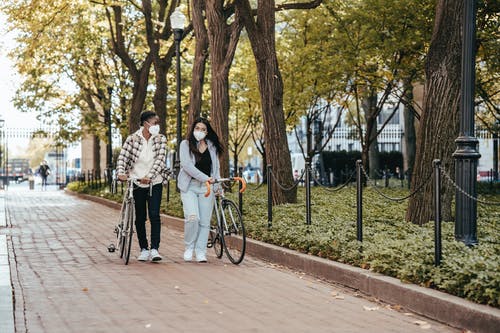 男人和女人在路上骑自行车 · 免费素材图片