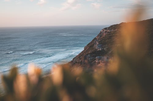 岩石海岸反对挥舞着蓝色的大海 · 免费素材图片