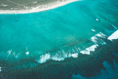 平静的蔚蓝大海附近的热带海岸线 · 免费素材图片