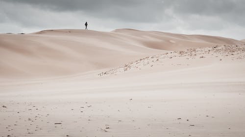 孤独的游客在沙丘上行走 · 免费素材图片