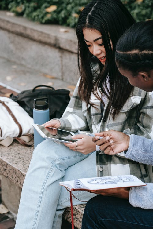 坐在棕色的混凝土长凳上的灰色外套的女人 · 免费素材图片