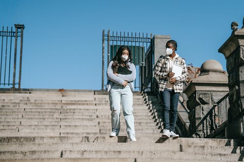 男人和女人站在棕色的水泥地板上 · 免费素材图片