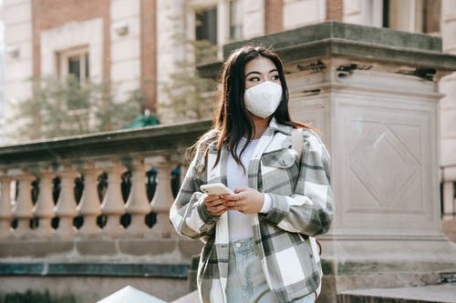 白色和黑色格子外套站在大楼附近的女人 · 免费素材图片