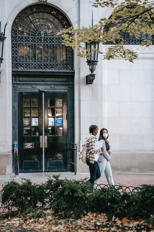 男人和女人在白色混凝土建筑前接吻 · 免费素材图片