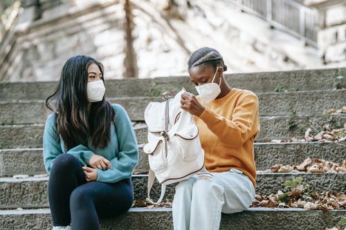 白色头巾和橙色长袖衬衫坐在棕色的木凳上的女人 · 免费素材图片