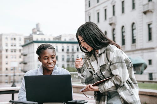 使用黑色便携式计算机的棕色和白色格子衬衫的女人 · 免费素材图片