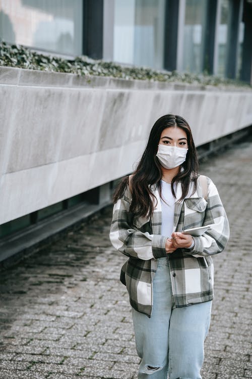 站在灰色的混凝土通路上的白色和黑色外套的女人 · 免费素材图片