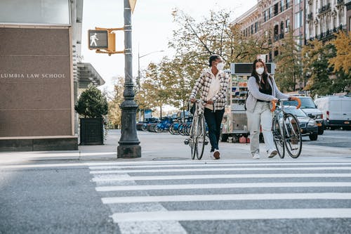 男人和女人在行人专用车道上骑自行车 · 免费素材图片