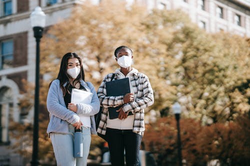 抱着一个婴儿在黑色和白色格子外套的灰色毛衣的女人 · 免费素材图片