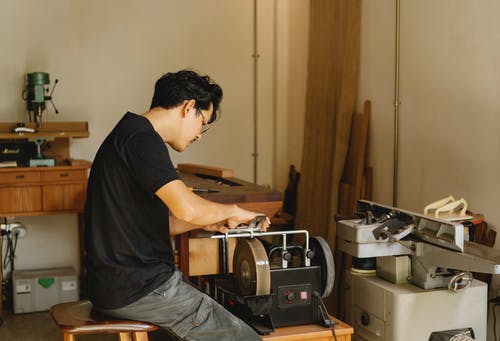 细心的民族工匠磨削工具在工作室的磨床上 · 免费素材图片