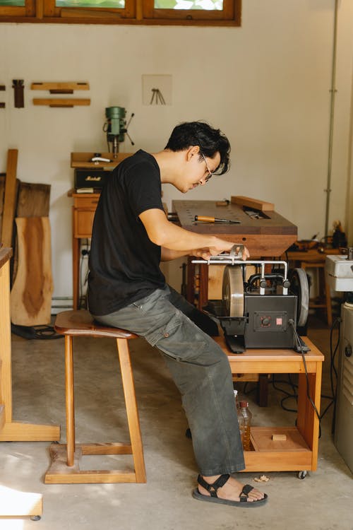 集中的民族工匠在磨刀机工作 · 免费素材图片