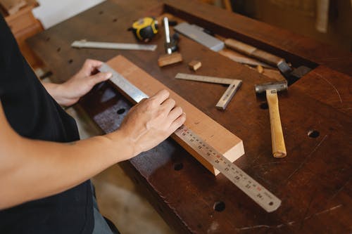 用尺子测量木板的人 · 免费素材图片