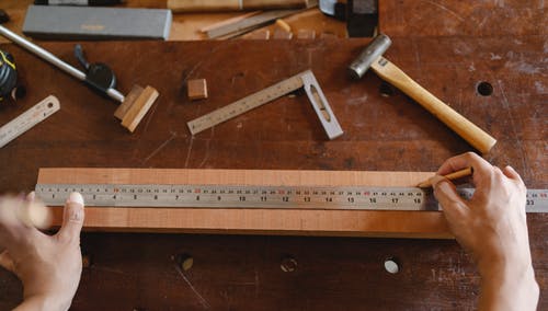 测量桌上的木板的人 · 免费素材图片