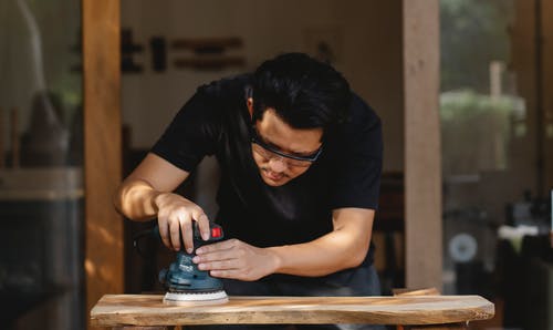 拿着黑色智能手机的黑色圆领t恤的男人 · 免费素材图片