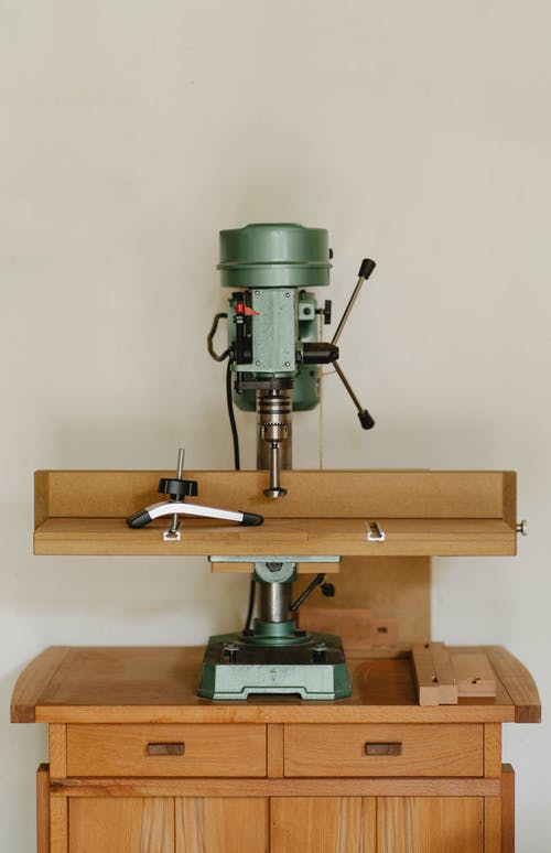 木制的桌子上的钻孔机 · 免费素材图片