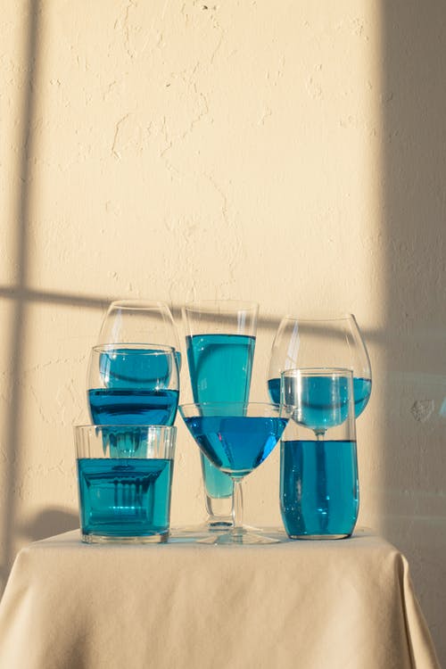 桌上摆满了蓝色液体的玻璃器皿 · 免费素材图片