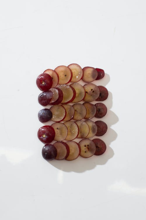切片的葡萄排列在白色的表面 · 免费素材图片