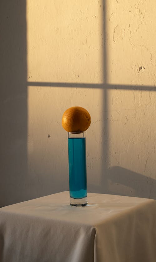 橙色与蓝色饮料放在玻璃上方 · 免费素材图片