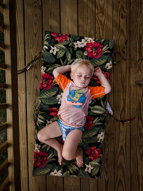 可爱的小男孩睡在床垫上 · 免费素材图片