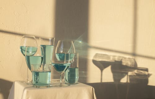 蓝色酒精饮料在桌上的眼镜 · 免费素材图片