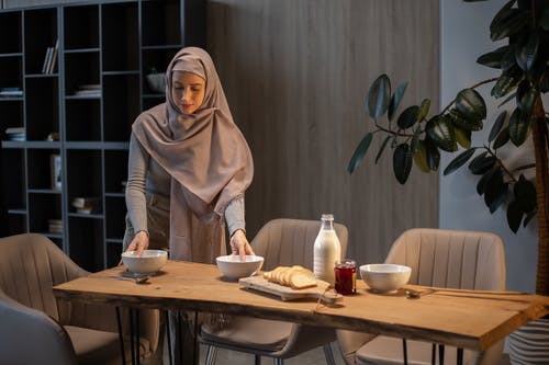 坐在桌旁的棕色头巾的女人 · 免费素材图片