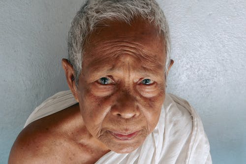 白墙附近严重亚洲老人 · 免费素材图片