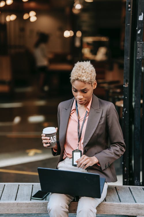 拿着白色陶瓷杯子的黑衣服夹克的人 · 免费素材图片