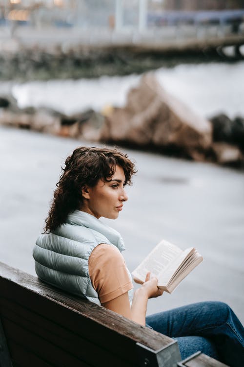 白色长袖衬衫阅读书中的女人 · 免费素材图片