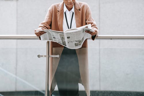 粉色西装外套阅读报纸的女人 · 免费素材图片