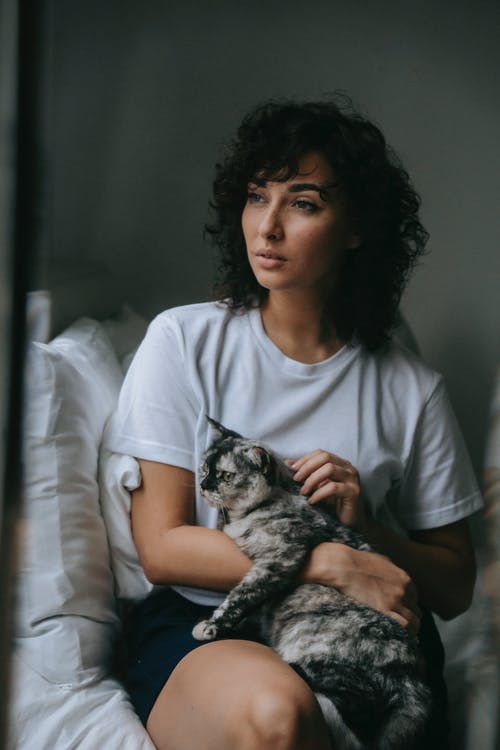 拿着棕色虎斑猫的白船员脖子t恤的女人 · 免费素材图片