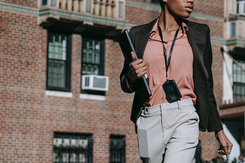 黑色西装外套和灰色的裤子，拿着黑色的平板电脑的人 · 免费素材图片