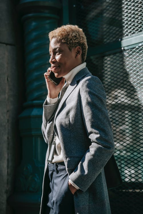 站在黑金属栅栏附近的灰色外套的男人 · 免费素材图片